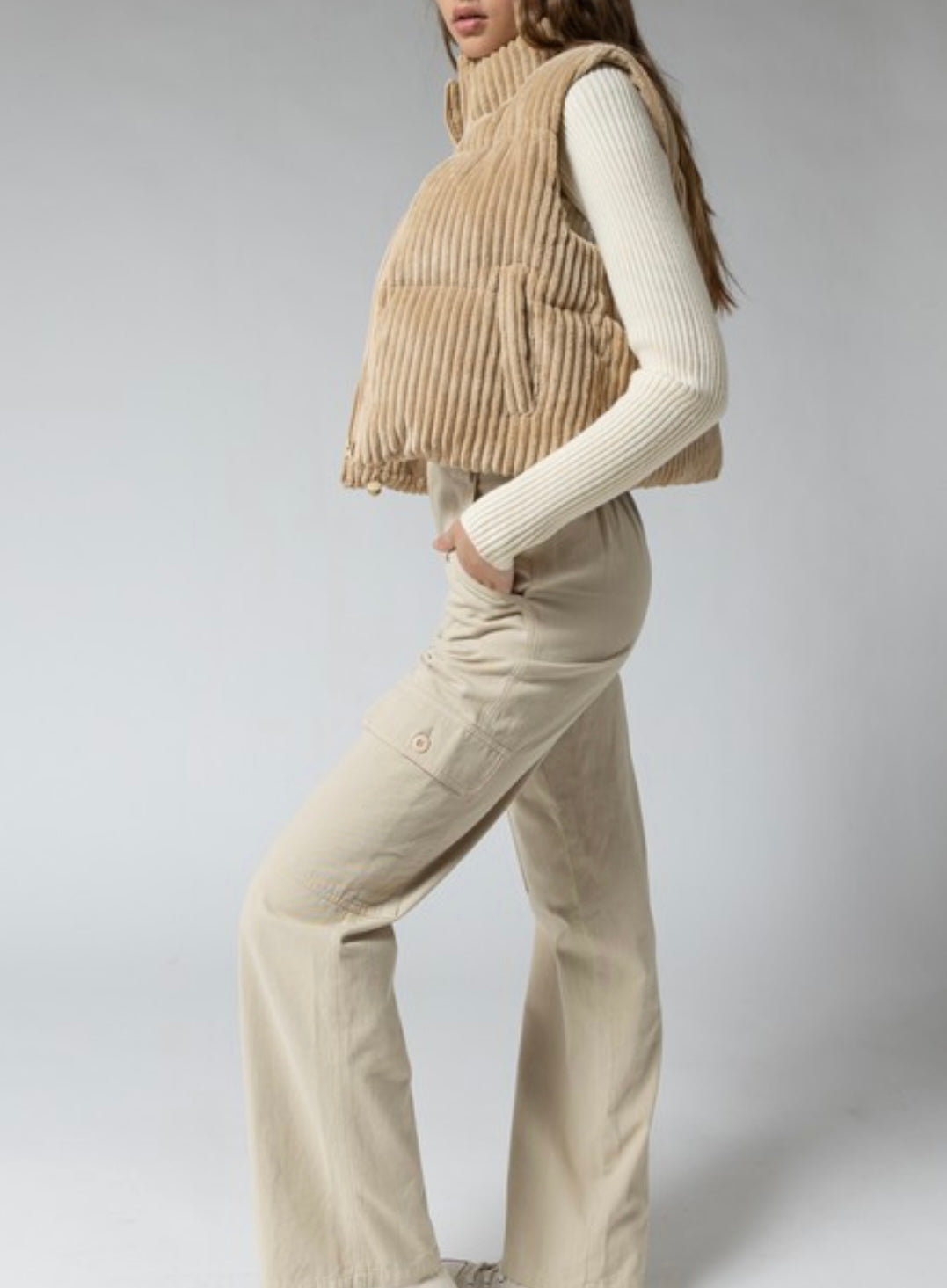 A stylish tan corduroy cropped puffer vest that's padded - a must-have for the outdoors.