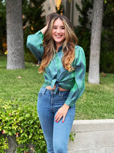 Load image into Gallery viewer, A shiny holographic green blue blouse with buttons and a high-low cut. The fit is loose with puff sleeves.