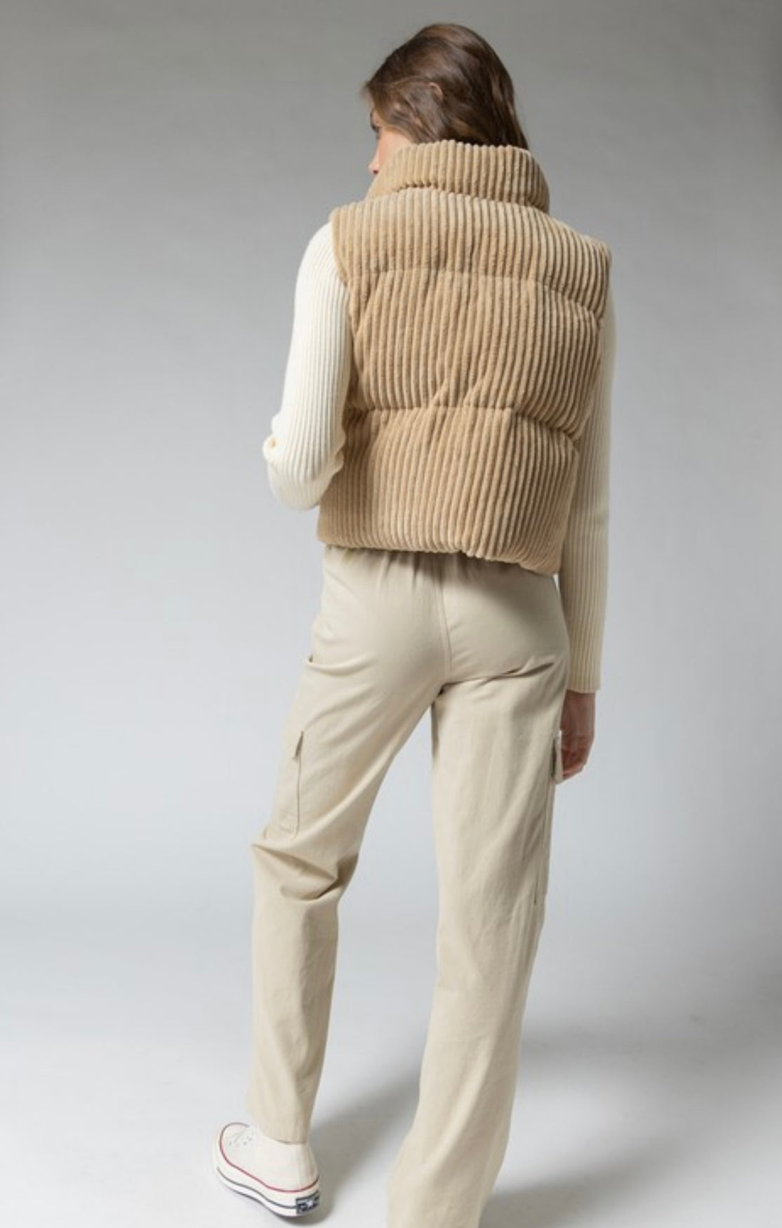 A stylish tan corduroy cropped puffer vest that's padded - a must-have for the outdoors. 