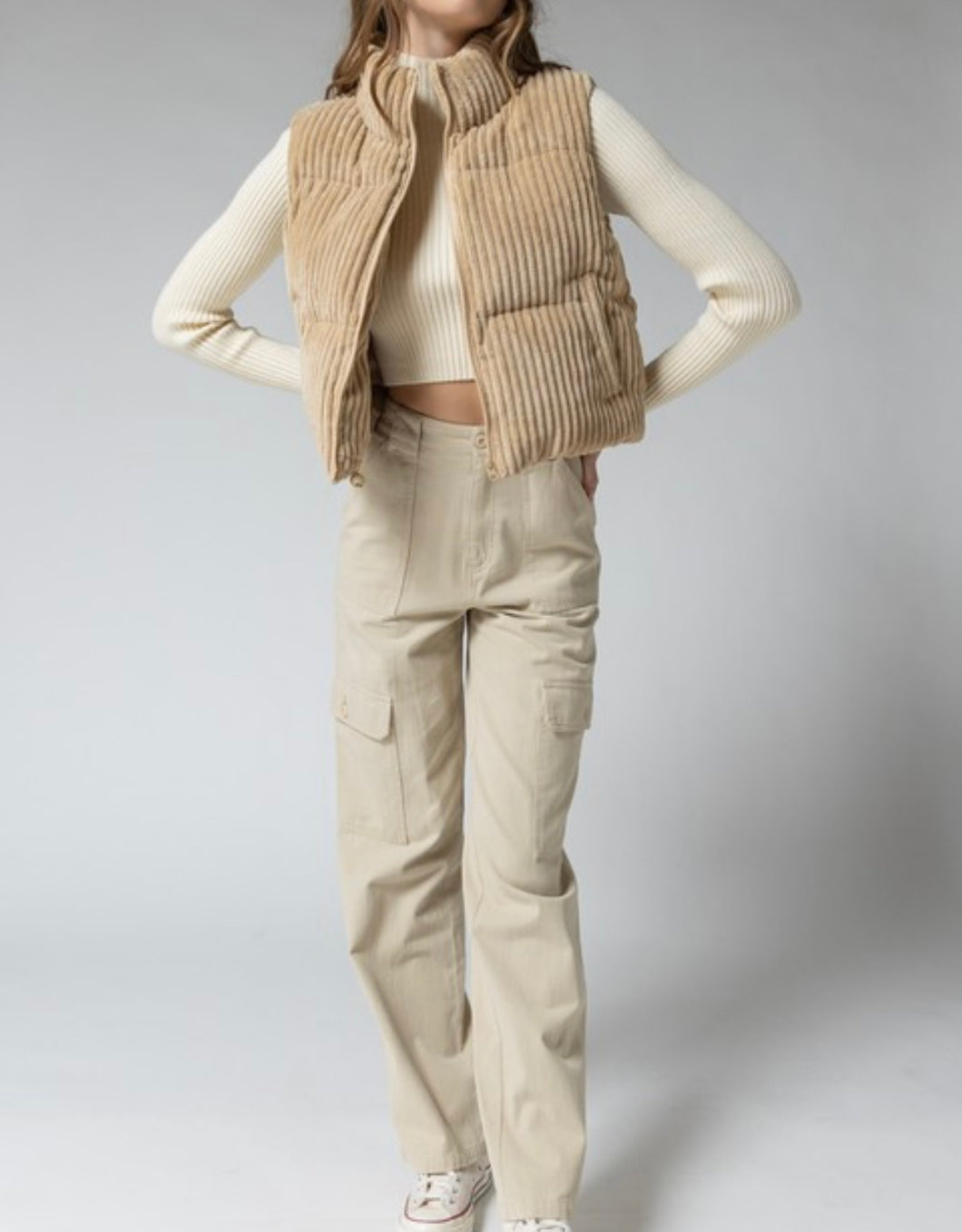 A stylish tan corduroy cropped puffer vest that's padded - a must-have for the outdoors. 